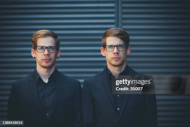 twin brothers standing next to each other - twin males stock pictures, royalty-free photos & images