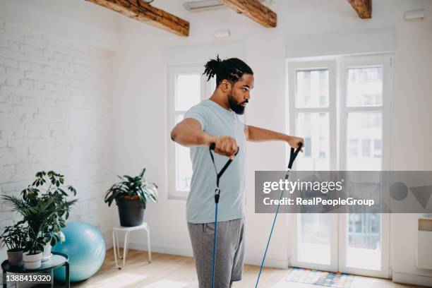 home workout routine. black man doing suspension straps exercises - men exercising stock pictures, royalty-free photos & images