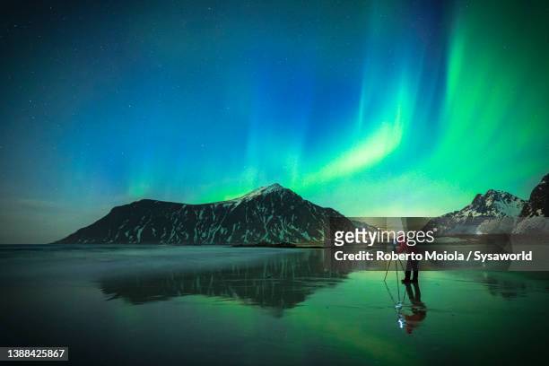 person photographing the sky during the northern lights - northern light photos et images de collection