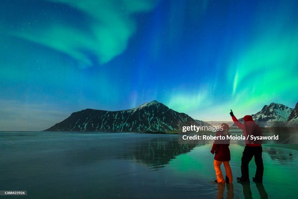 Man and woman watching Northern Lights from Skagsanden beach