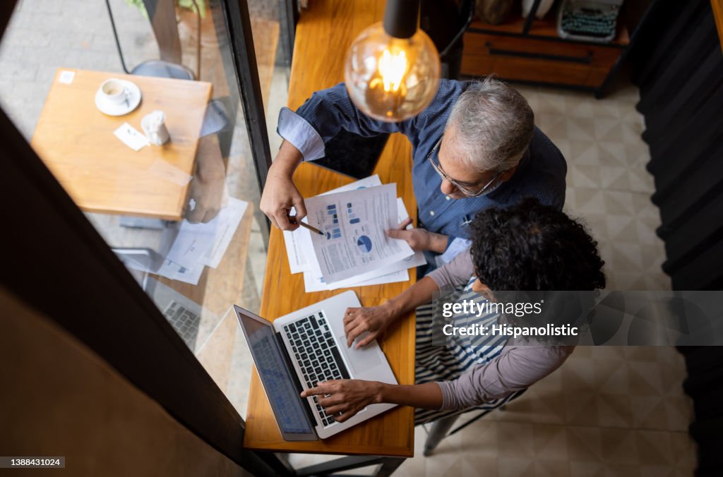 Business owner and manager working on the finances of the shop using a laptop