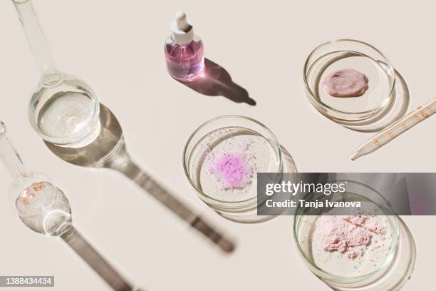 laboratory glassware and cosmetic glass bottles on beige background. natural medicine, cosmetic research, bio science, organic skin care products. top view, flat lay. research and development concept. - lab flask imagens e fotografias de stock