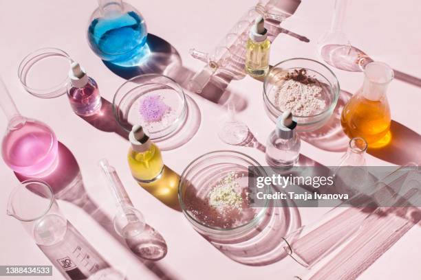 colorful background with laboratory utensils, samples of cosmetics and glass vials on pink background. natural medicine, cosmetic research, bio science, organic skin care products. top view, flat lay. - skin care ingredients stock pictures, royalty-free photos & images