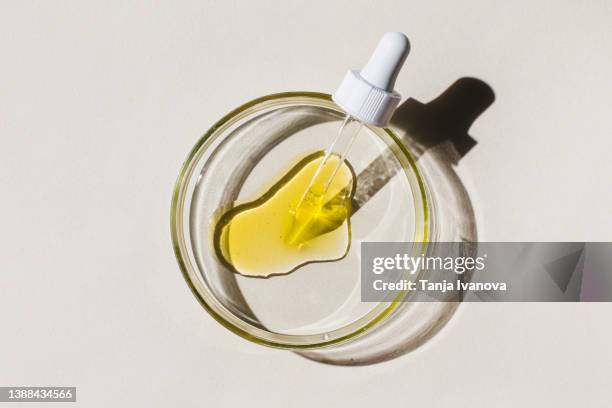 petri dish with pipette and cosmetic liquid on beige background. concept of laboratory research of cosmetics. science of dermatology. natural medicine, cosmetic research, organic cosmetics. top view, flat lay. - boîte de pétri photos et images de collection