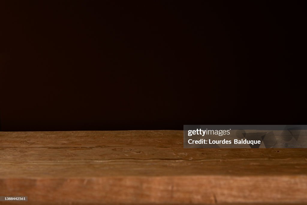 Wooden Table Against Dark Wall Background