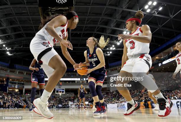 Paige Bueckers of the UConn Huskies heads for the net as Kayla Jones and Kai Crutchfield of the NC State Wolfpack defend in the first half during the...