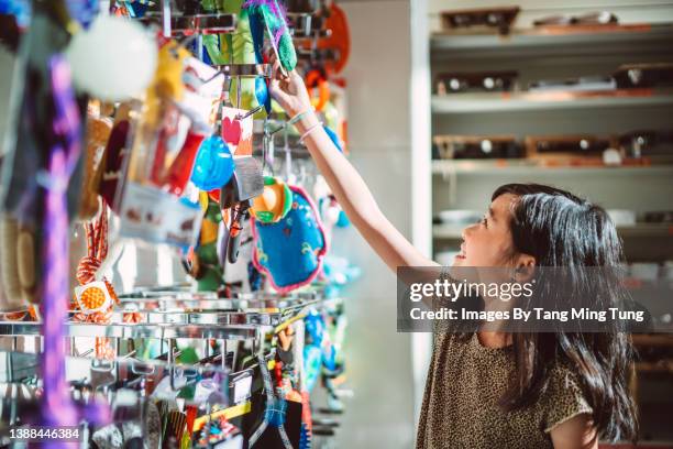 lovely girl shopping for pet toy in store joyfully - toy animal stock photos et images de collection