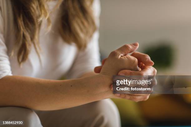 anxious young woman cracking her knuckles while contemplating problems - knuckle stock pictures, royalty-free photos & images