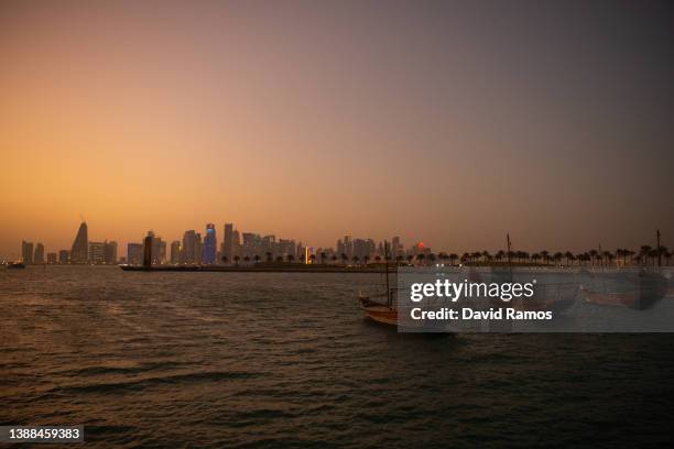 Dhows are seen at Doha Bay with the skyline of the city in the background at sunset on March 29, 2022 in Doha, Qatar.