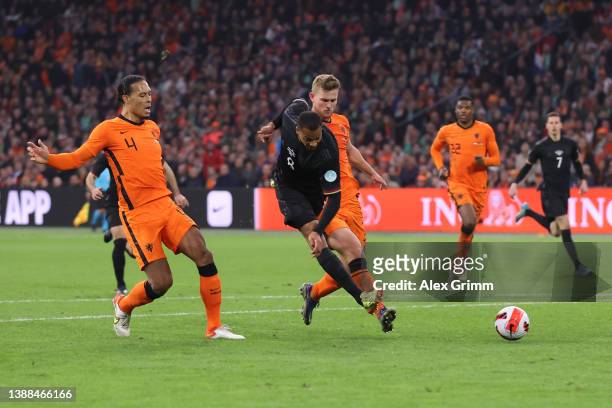 Lukas Nmecha of Germany shoots under pressure from Virgil van Dijkand Matthijs de Ligt of Netherlands during the international friendly match between...