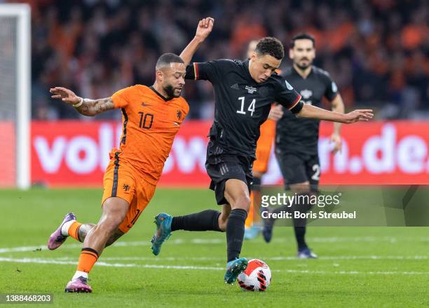 Jamal Musiala of Germany is challenged by Memphis Depay of the Netherlands during the international friendly match between Netherlands and Germany at...