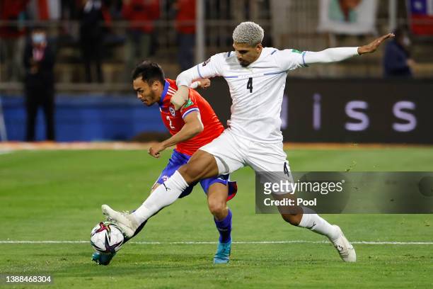 Ronald Araujo of Uruguay fights for the ball with Charles Aranguiz of Chile during the FIFA World Cup Qatar 2022 qualification match between Chile...