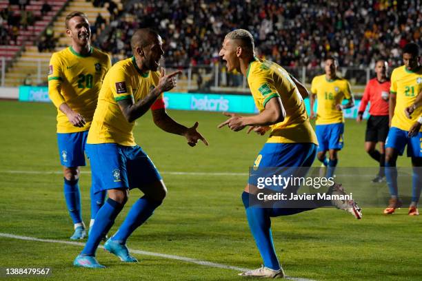 Richarlison of Brazil celebrates with teammate Dani Alves after scoring the fourth goal of his team during a match between Bolivia and Brazil as part...