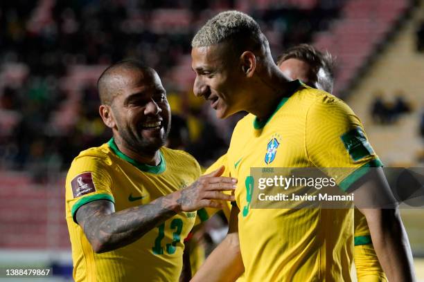 Richarlison of Brazil celebrates with teammate Dani Alves after scoring the fourth goal of his team during a match between Bolivia and Brazil as part...