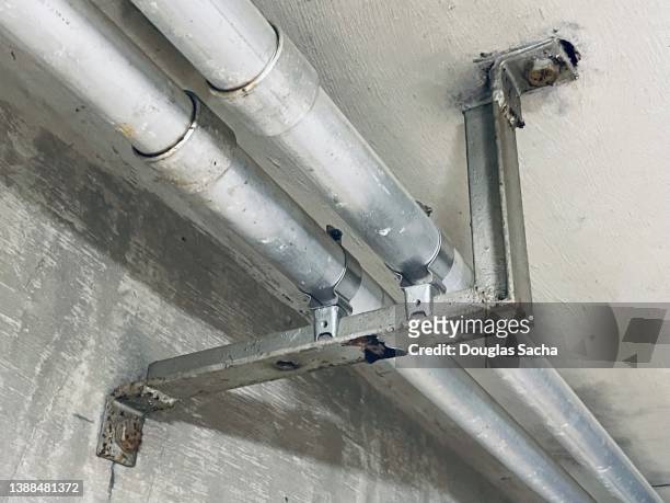 wall bracket holding up pipes - bracket household fixture stock-fotos und bilder