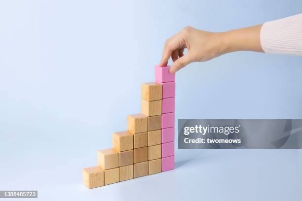 growth chart concepts still life with wooden cubes stacks. - human hand positions stock pictures, royalty-free photos & images