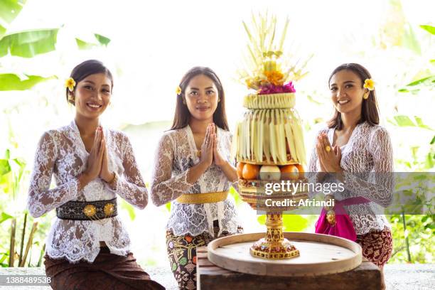 balinese women arranging an offering called gebogan - ubud rice fields stock pictures, royalty-free photos & images