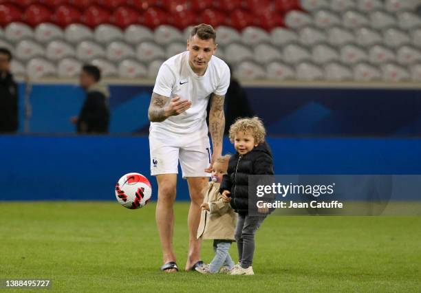 Lucas Digne of France plays with his son Isaho Digne and his daughter Inahaya Digne on the pitch following the international friendly match between...