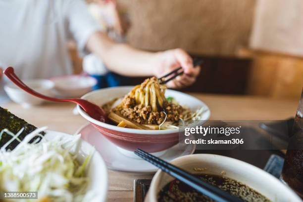 hand using chopstick picking hot soup ramen noodle with chili soup and tsukemen noodle  japanese style - カレーうどん ストックフォトと画像