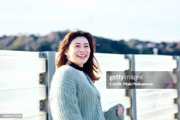 a portrait of woman standing on a breakwater. - groyne stock pictures, royalty-free photos & images