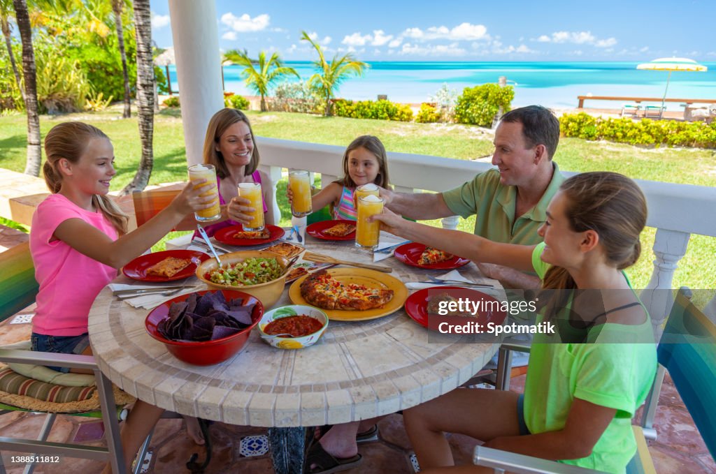 Parents and daughters having family lunch at beach bar