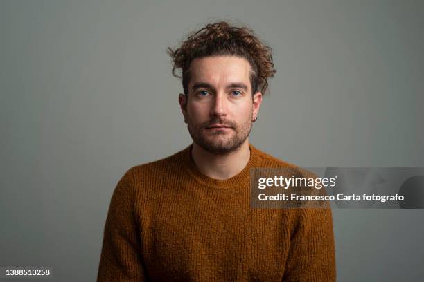 sad young man on gray background - sad face stock-fotos und bilder