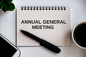 Annual general meeting text on notepad with office concept background. Conceptual