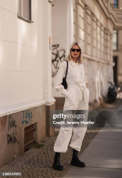 Lena Gercke seen wearing a white denim overall from LeGer, a black sunglasses from Prada, silver earrings from LeGer, a black handbag from LeGer and...