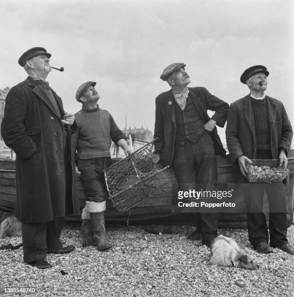 Local fishermen, from left, Tom Gribben, William Shilson, Charles Spicer and Philip Betts, posed with a dog on the beach in the seaside town of Deal...