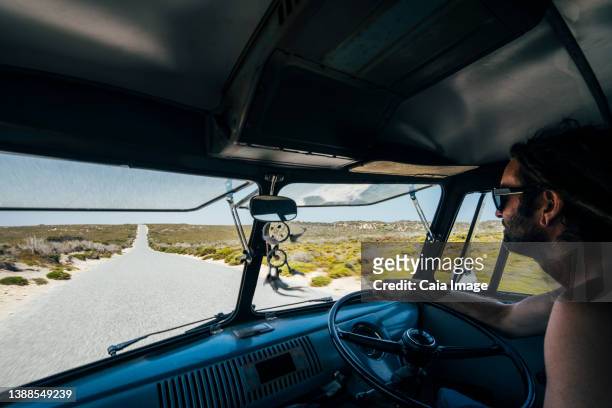 man driving van on remote road in australian bush - australian bus driver stock-fotos und bilder