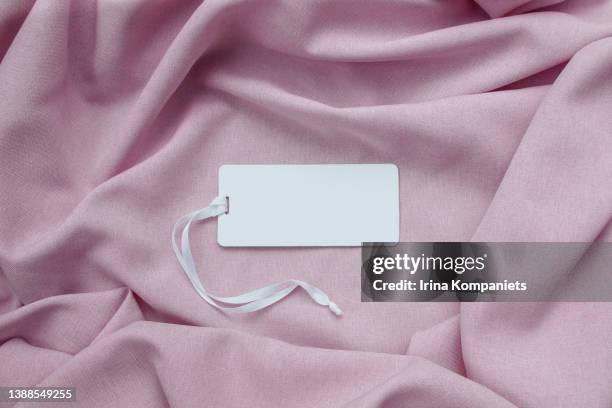 white empty paper label with a ribbon on a background of pink fabric close-up. - luxury mall bildbanksfoton och bilder