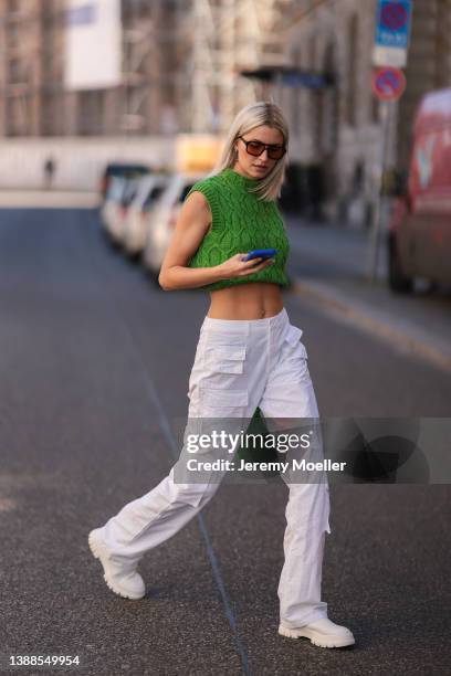 Lena Gercke seen wearing a brown 'Dixie' sunglasses from Vehla, silver earrings from LeGer, a green LeGer knit sweater vest, a white denim LeGer...