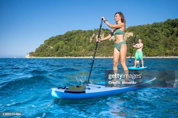paddleboarding di coppia in mare - paddle surf foto e immagini stock