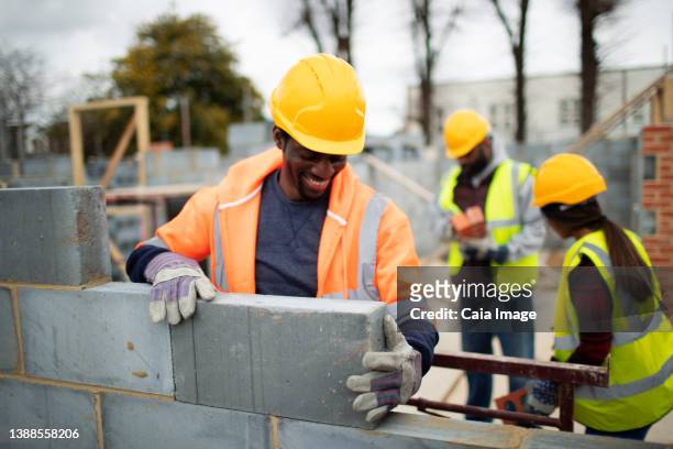 male construction worker laying brick at construction site - dedication brick stock pictures, royalty-free photos & images