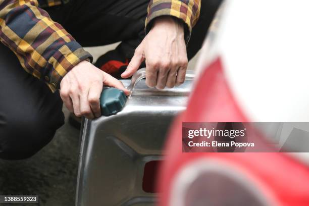 cropped man's hands opening gasoline canister for refueling car - canister stock pictures, royalty-free photos & images