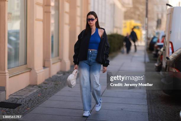 Antonia Sophie seen wearing a black LeGer bomber jacket with white logo back print, a black retro sunglasses from Chimi, a blue crop top from LeGer,...