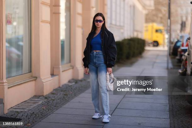 Antonia Sophie seen wearing a black LeGer bomber jacket with white logo back print, a black retro sunglasses from Chimi, a blue crop top from LeGer,...