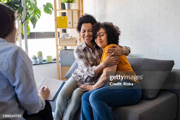 lesbian couple getting relationship counseling by therapist - couple doctor stock pictures, royalty-free photos & images