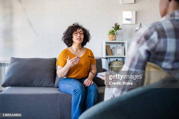 mid adult woman talking to her therapist - mental health awareness month stock pictures, royalty-free photos & images