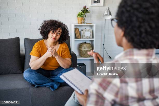 woman  talking with a therapist about her mental issues - mental health awareness month stock pictures, royalty-free photos & images