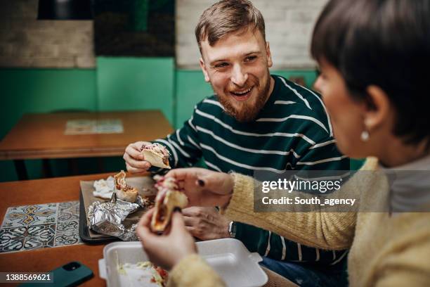 couple eating burritos - mexican food on table stock pictures, royalty-free photos & images