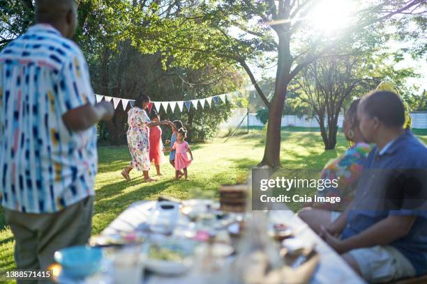 mother and daughters in dresses dancing in sunny summer backyard - senior man dancing on table stock pictures, royalty-free photos & images