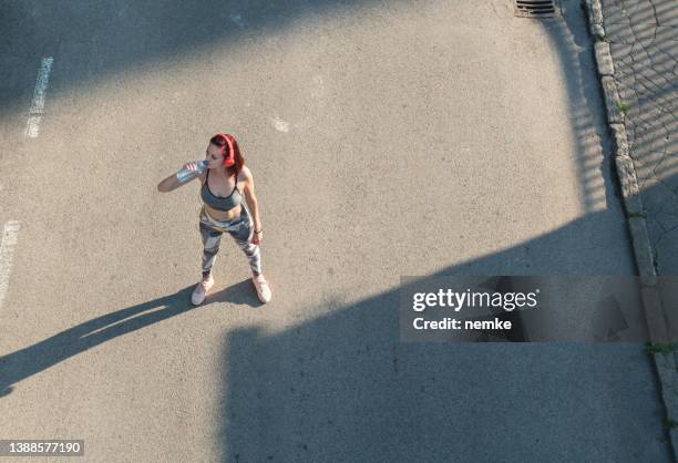 top view woman drinking from water bottle - electrolyte stock pictures, royalty-free photos & images