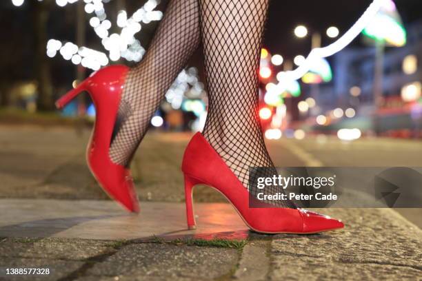 womans legs and shoes on street at night - tacones altos fotografías e imágenes de stock