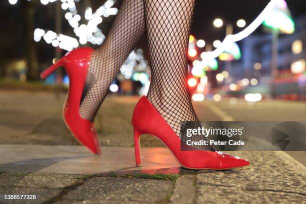 womans legs and shoes on street at night - high heel stockfoto's en -beelden