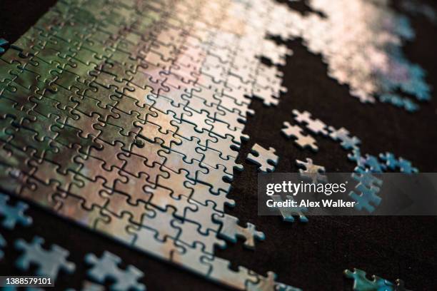 partially completed jigsaw puzzle on black background - the bigger picture imagens e fotografias de stock