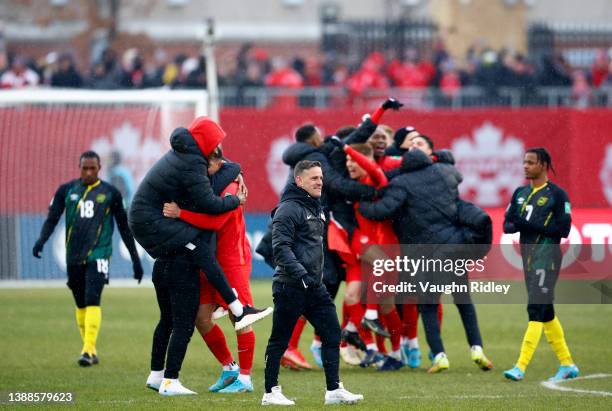 Head Coach John Herdman of Canada looks on while his players celebrate victory following a 2022 World Cup Qualifying match against Jamaica at BMO...