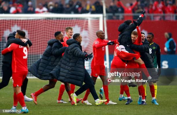 Cyle Larin, Atiba Hutchinson, Jonathan Osorio, Liam Fraser, Stephen Eustáquio of Canada celebrate victory with teammates following a 2022 World Cup...