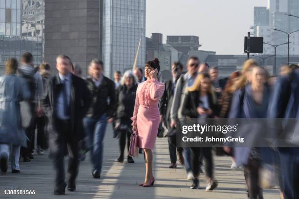 executive dressed in pink using phone during morning commute - unico imagens e fotografias de stock