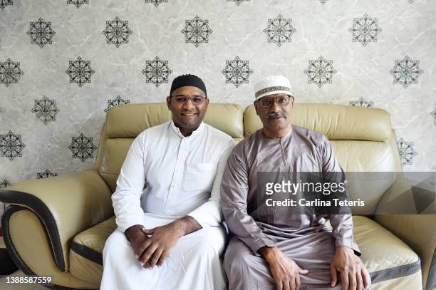 portrait of singaporean indian man and his father on hari raya - indian muslims celebrate eid ul fitr stock pictures, royalty-free photos & images